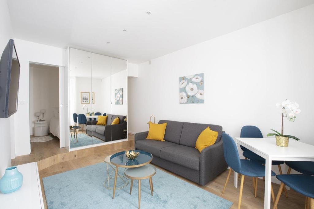 巴黎Stylist and cosy appartement in Montparnasse的客厅配有沙发和桌子