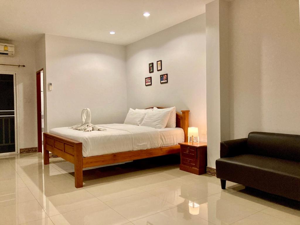 华欣班约克哈尼酒店的一间卧室配有一张带椅子和沙发的床