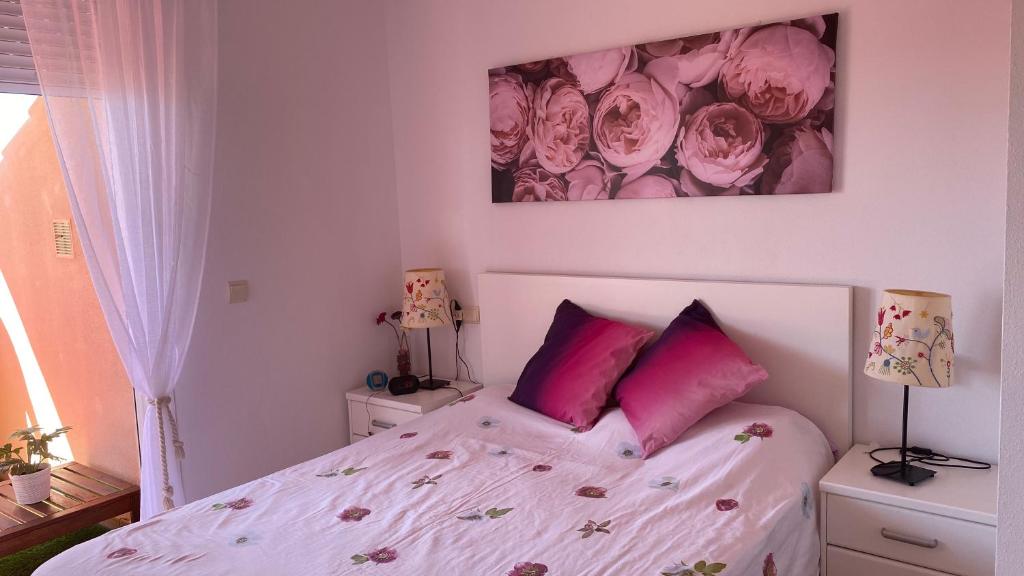 圣路易斯·德·萨比尼尔Precioso ático con vistas al mar, junto a Mercadona的卧室配有白色床和粉红色枕头
