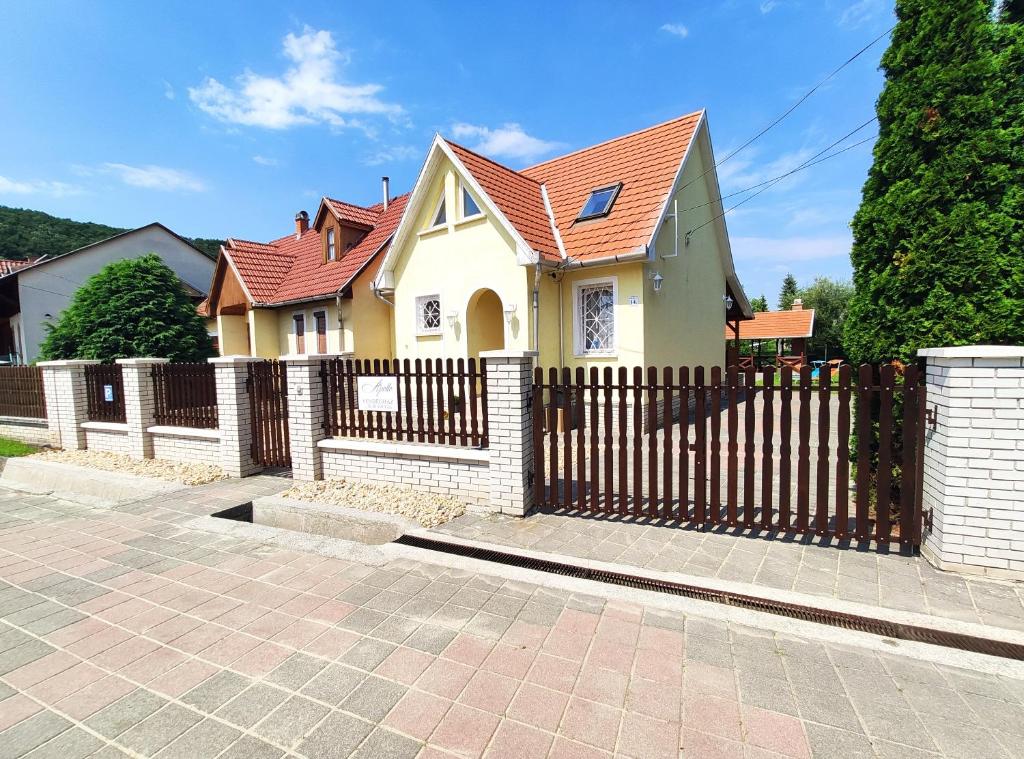 博加奇Apollo Vendégház的黄色的房屋,设有木栅栏