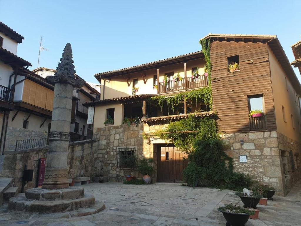 Valverde de la VeraCasa Rural La Picota的一座石头建筑,旁边设有阳台