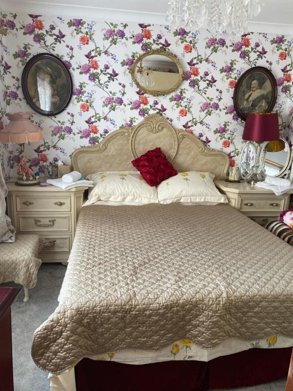 拉姆斯盖特Na的卧室配有一张墙上鲜花的床