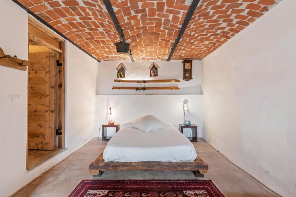 瓜热讷Greeneria的一间卧室设有一张床和砖砌天花板