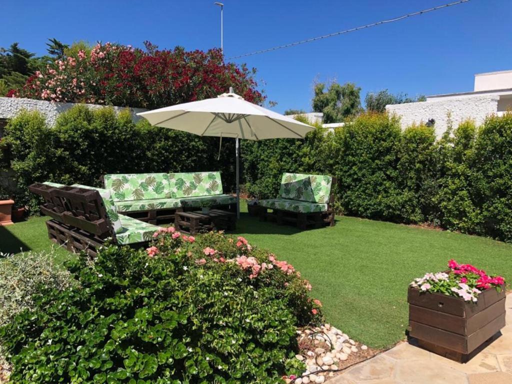 托雷奇安卡Villetta Martino Guest House的花园配有两把椅子和一把遮阳伞
