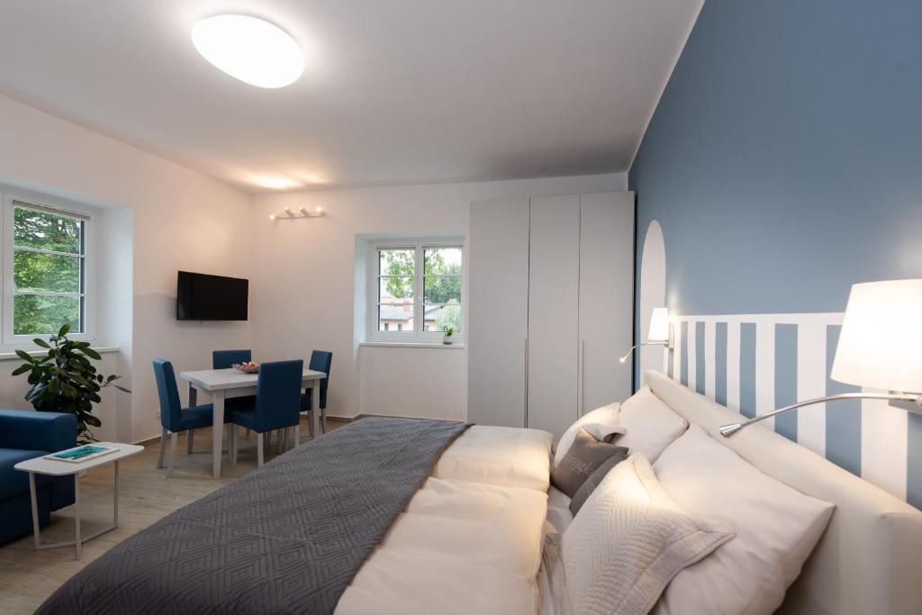 沃尔特湖畔佩莎赫Villa Bella Vista - Apartment Blue的一间卧室配有一张床和一张桌子及椅子