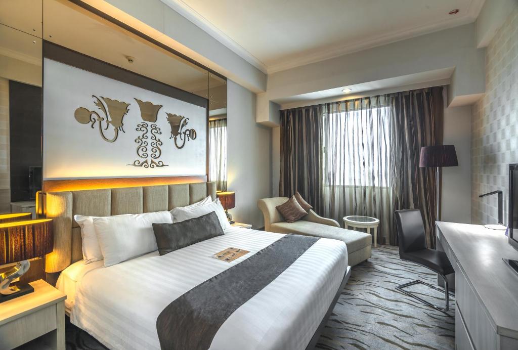 泗水维尔伍德服务公寓及酒店的酒店客房设有一张大床和一张沙发。