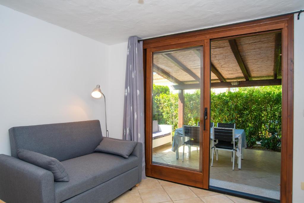 奥尔比亚Appartamento del Cormorano的带沙发和滑动玻璃门的客厅