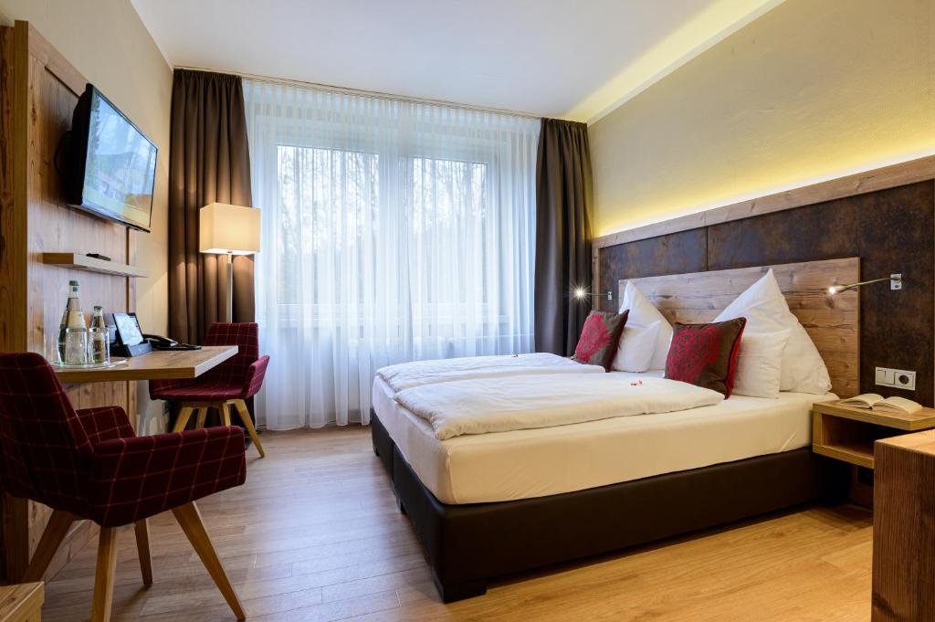 卢森塔尔博格霍夫瓦德酒店的酒店客房设有一张大床和一张书桌。