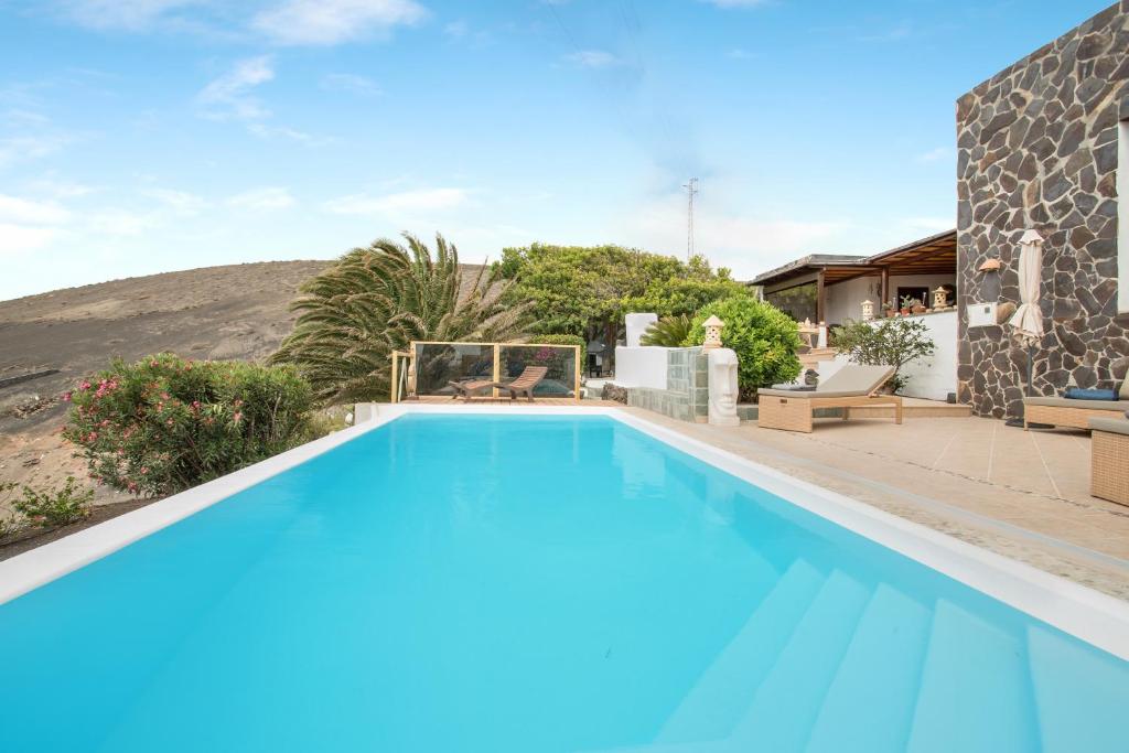阿索马达Pure La Asomada的一座房子前面的蓝色海水大型游泳池