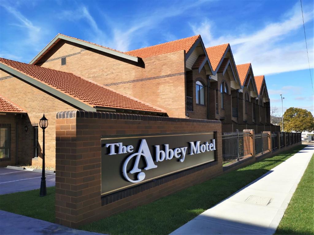 古尔本The Abbey Motel Goulburn的大楼前狗儿旅馆的一个标志