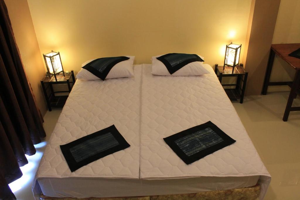 沙湾拿吉阿瓦隆公寓的一张大床,位于带两盏灯的房间