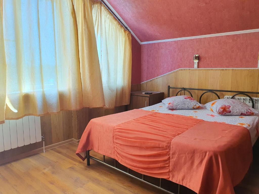 涅温诺梅斯克Hotel Economy Classa Edelweiss的一间卧室配有一张带橙色毯子的床