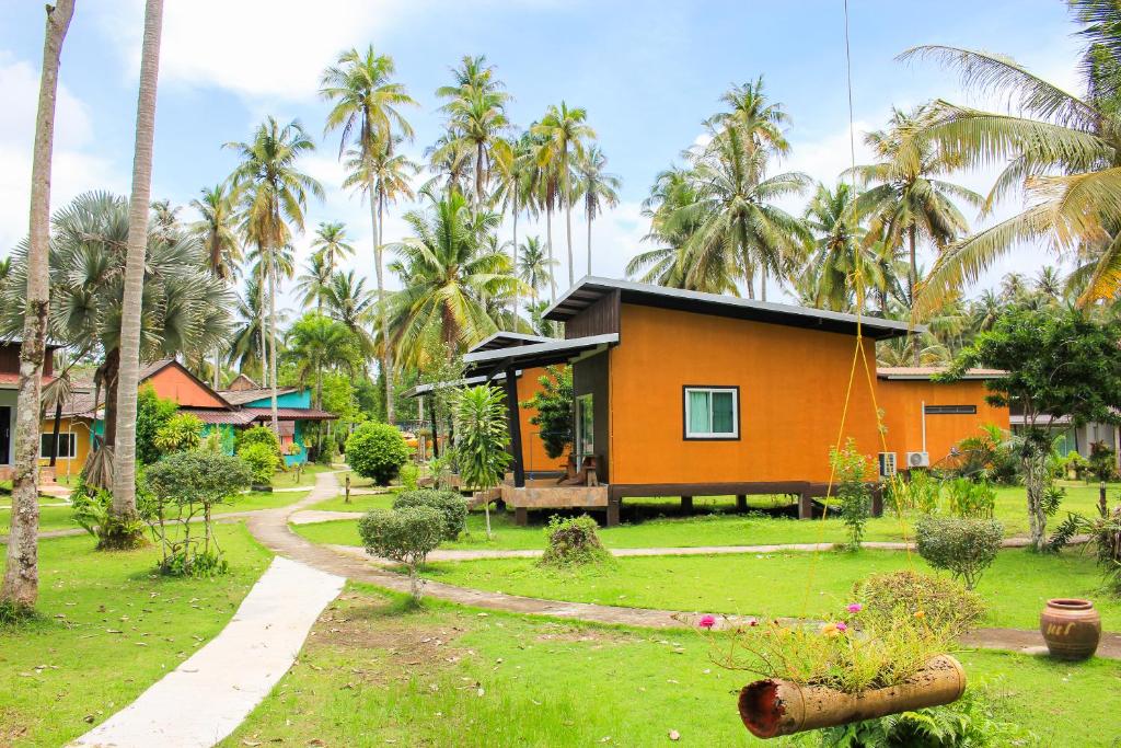 库德岛Koh Kood Far East Resort的棕榈树庭院中间的房子