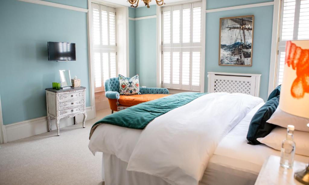 海斯廷斯Moore House的卧室拥有蓝色的墙壁,配有一张床和椅子