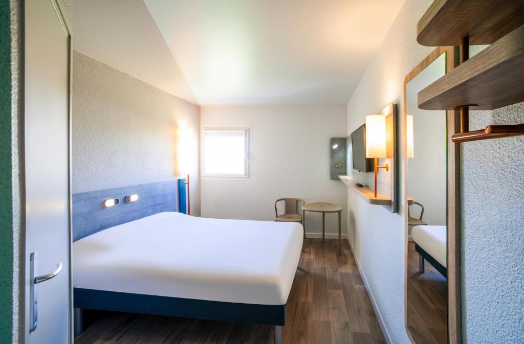 尼伊圣乔治圣乔治之夜宜必思快捷酒店的小房间设有白色的床和窗户