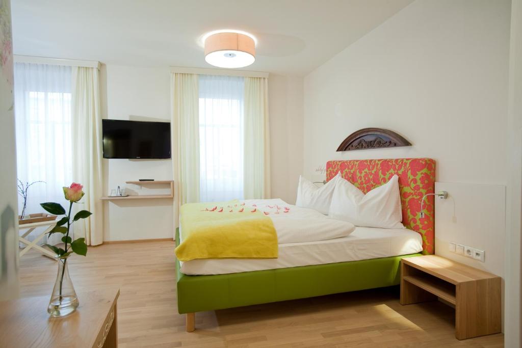 哈特贝格泽姆布劳豪斯餐厅旅馆的一间卧室配有一张带黄色毯子的大床