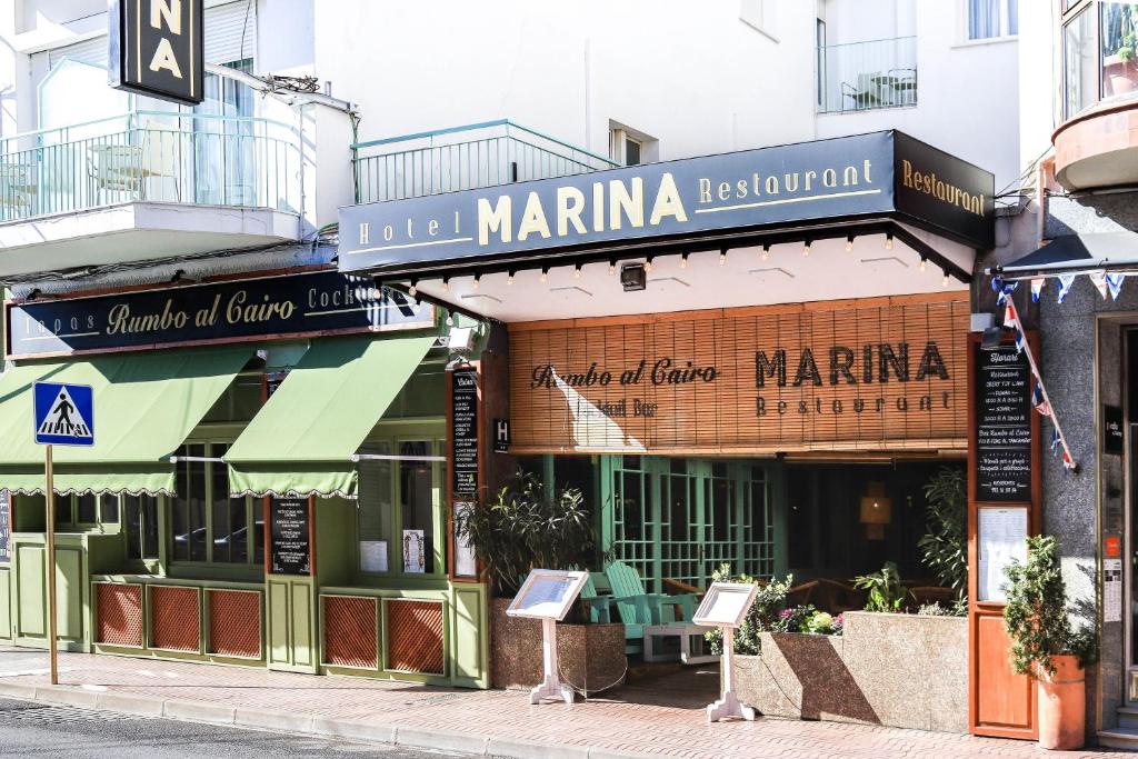 帕拉莫斯Hotel & Restaurant Marina Palamós的街道一侧有标志的建筑