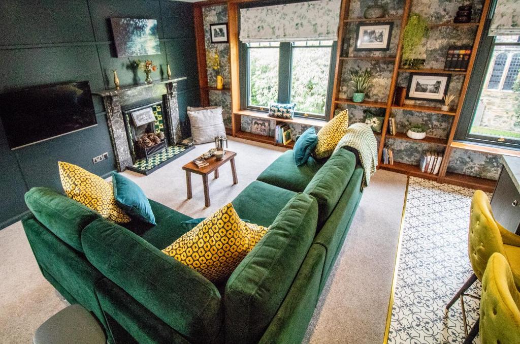 塞德伯Wuthering Heights的客厅设有绿色沙发和壁炉