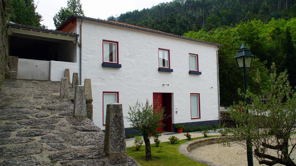阿马里什Casa Abrigo do Lagar的白色的建筑,有红色的窗户和街灯