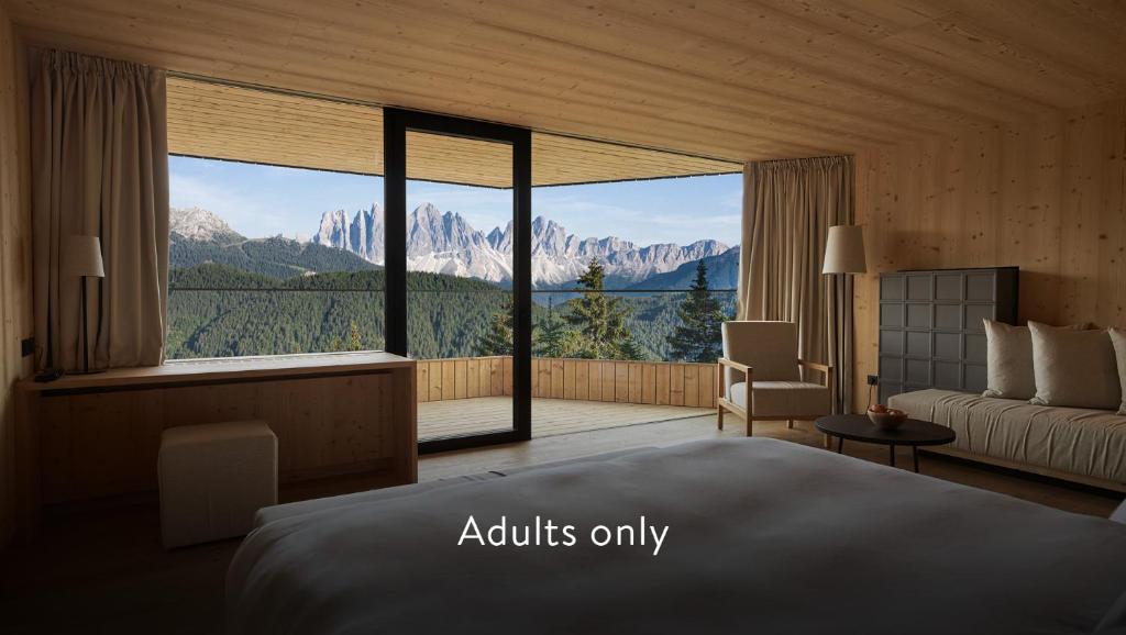 布列瑟农Forestis Dolomites的一间卧室设有一张床和一个大窗户