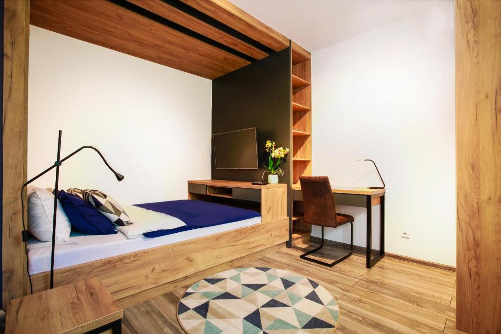 利马诺瓦Apartament z ogrodem w centrum Limanowej的一间卧室配有一张床和一张书桌