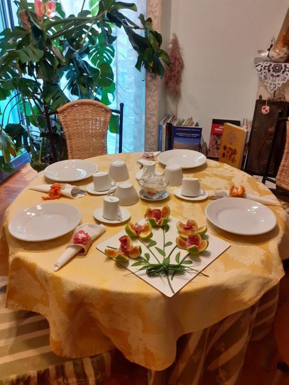 阿尔塔穆拉B&B Stupor Mundi的一张桌子,上面有白色的板子和鲜花