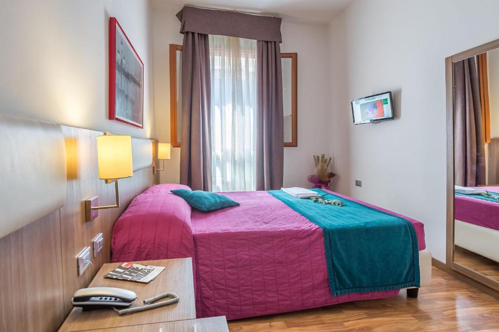 威尼斯伊尔摩洛威尼斯酒店的一间卧室配有一张床和一张桌子及电话