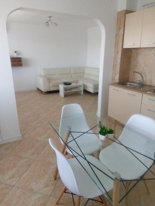 图尔恰Apartament bell confort的客厅配有玻璃桌和白色椅子