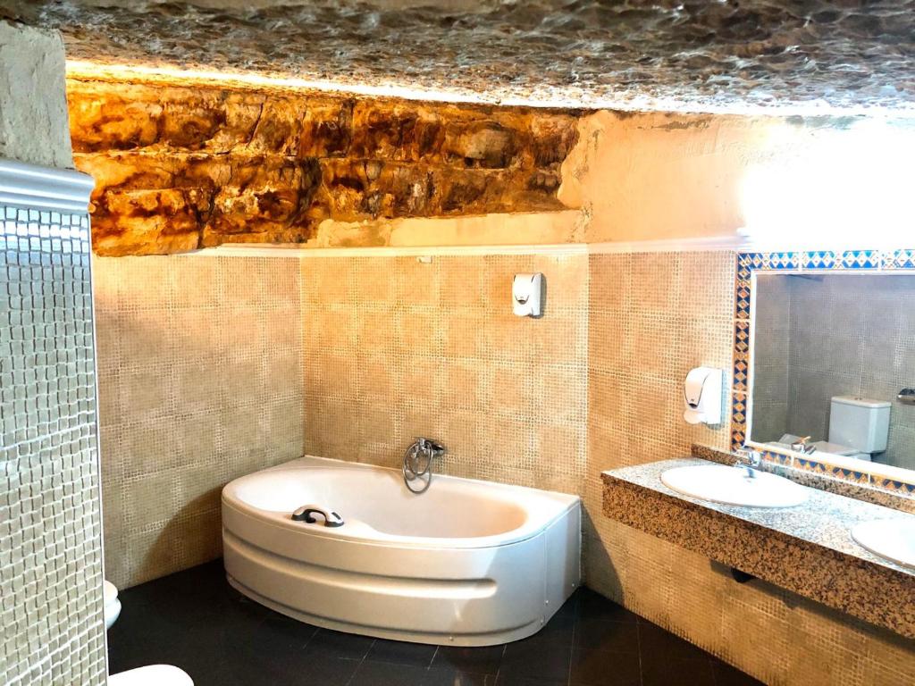 塞普尔韦达Hostal Posada La Panadera的浴室配有盥洗盆、卫生间和浴缸。