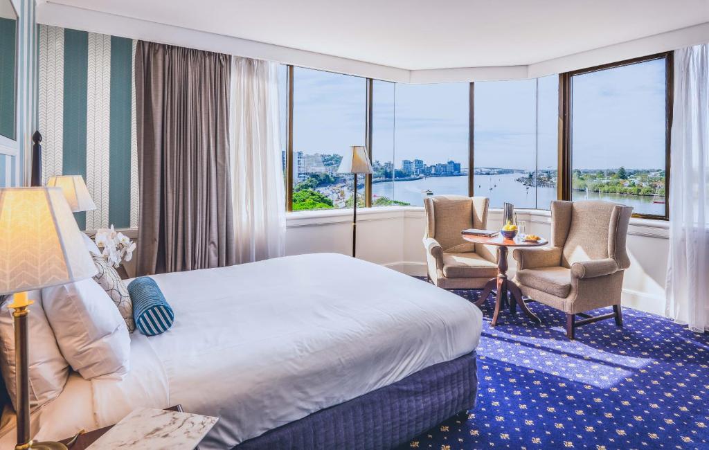 布里斯班View Brisbane的酒店客房带一张床、一张桌子和椅子