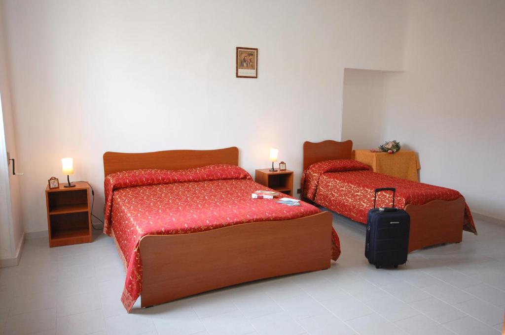 莱乌卡阿尔伯托德塞图里奥酒店的一间卧室配有两张床和行李箱