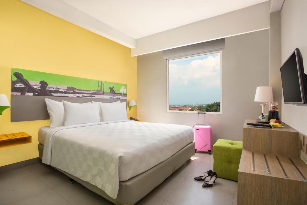泗水KHAS Surabaya的一间卧室设有一张大床和一个窗户。