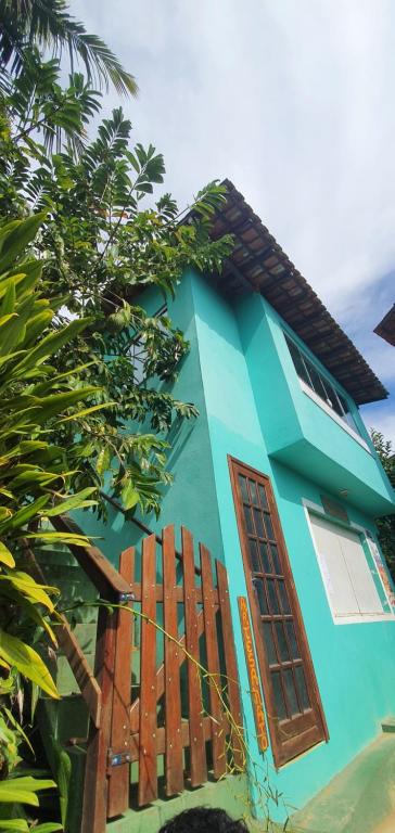 阿拉夏奇巴海滩Flat do Léo的蓝色的房子,设有窗户和栅栏