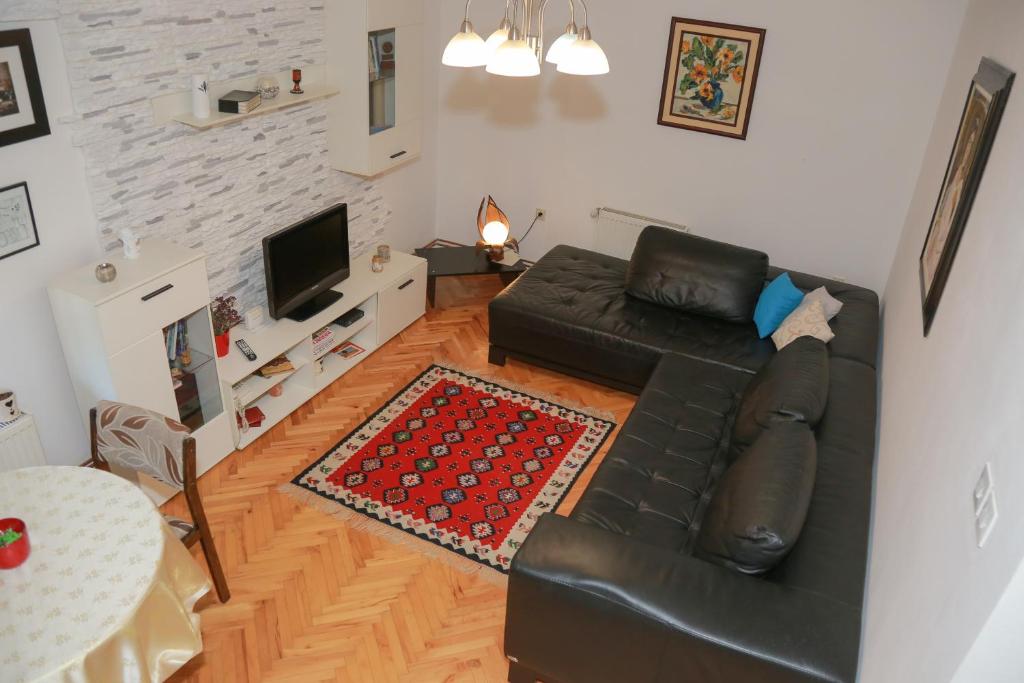 皮罗特Apartman Marija的客厅配有黑色真皮沙发和电视
