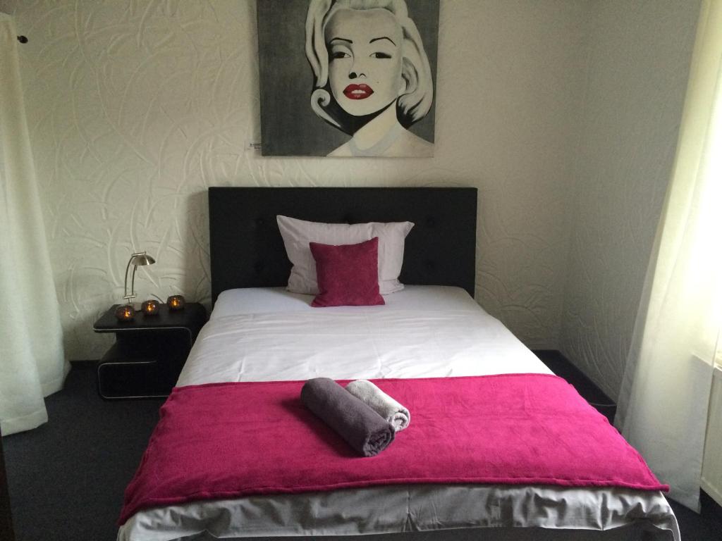 杜塞尔多夫格里旅馆的一间卧室配有一张带粉色毯子的大床