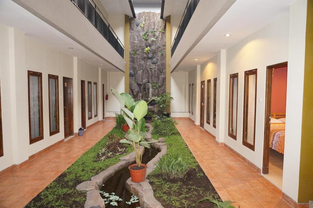日惹日惹阿罗哈酒店的建筑中间带花园的走廊