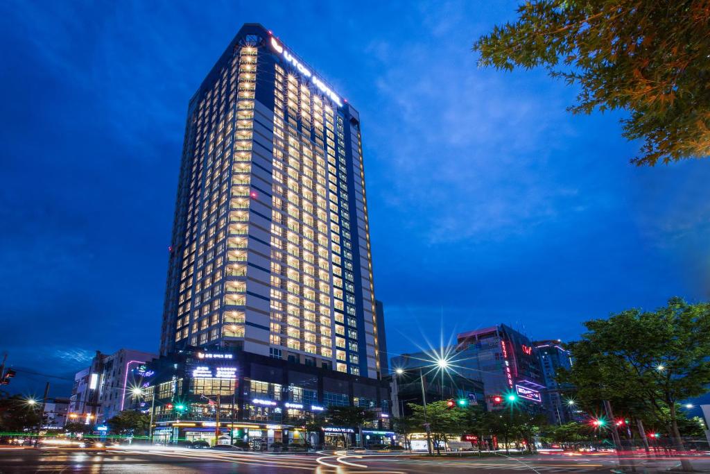 光州Utop Boutique Hotel&Residence的一座高大的建筑,晚上有灯