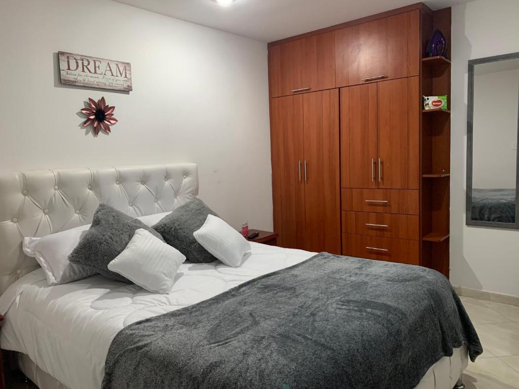 富萨加苏加Hermoso apartamento con parqueadero的一间卧室配有一张大床和一个木制橱柜