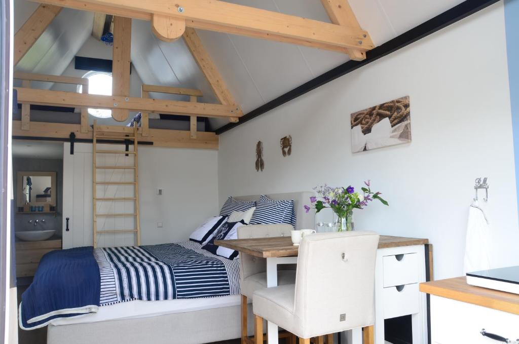 Woerdense VerlaatFroukje's B&B的一间卧室配有一张床、一张书桌和一张高架床