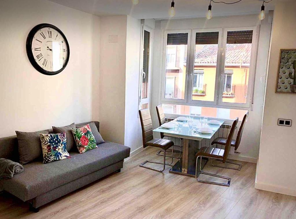 萨拉戈萨Apartamento Vive Zaragoza II的带沙发、桌子和时钟的客厅