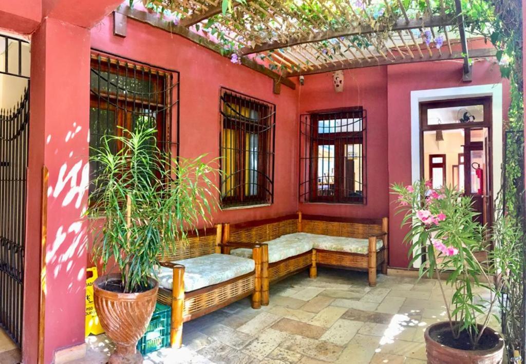 福塔莱萨Pousada Fortal Villa Praia的一个带长凳和红色墙壁的门廊