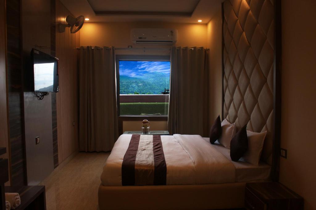 哈里瓦Hotel Ganga Heights的一间卧室设有一张大床和一个窗户。