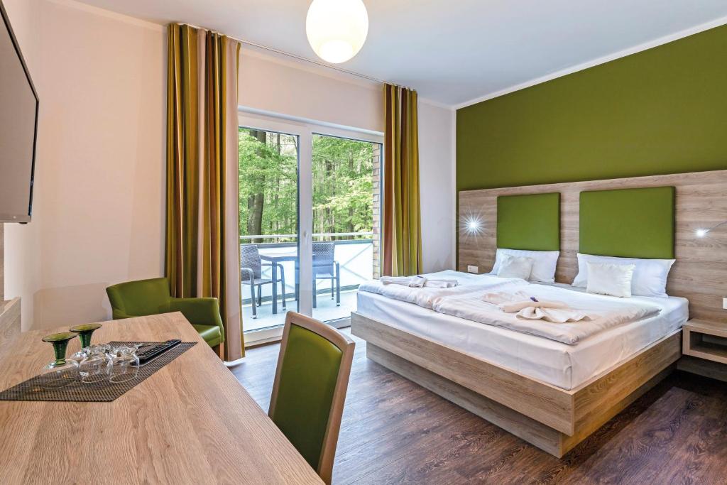 格拉尔-米里茨波罗的海酒店的一间卧室配有一张大床和一张餐桌