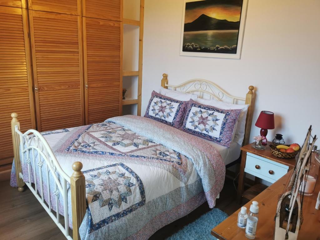 韦斯特波特Catherine's Lair A Quiet peaceful Homestay的一间卧室配有一张床和一个木制橱柜