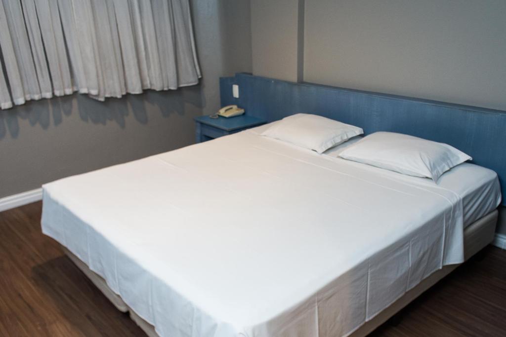 阿雷格里港Master Express Alberto Bins - 200 metros do Hospital Santa Casa的一张白色的大床,在房间里设有蓝色床头板