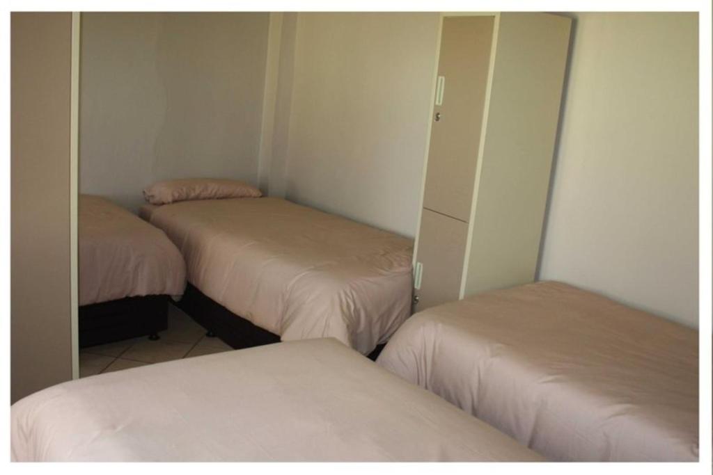 LephalaleAbuelita Guesthouse - Room 1的客房设有两张床和带镜子的衣柜。