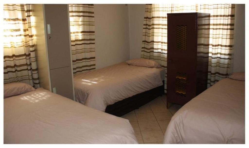 LephalaleAbuelita Guesthouse - Room 4的一间卧室配有两张床和镜子