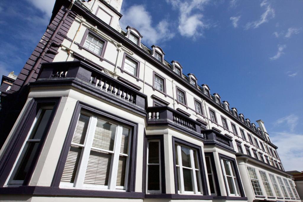 卡莱尔Carlisle Station Hotel, Sure Hotel Collection by BW的一座带白色窗户和蓝天的大型建筑