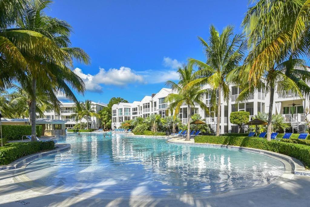 基拉戈LICENSED MGR - 4/3.5 MODERN VILLA - KEY LARGO'S MOST UPSCALE OCEANFRONT RESORT DESTINATION!的度假村前方棕榈树游泳池