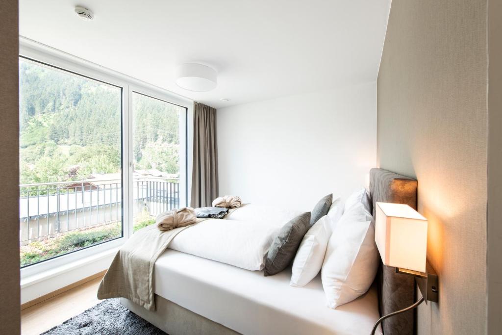 迈尔霍芬MANNI village - lifestyle apartments的一间卧室设有一张床和一个大窗户